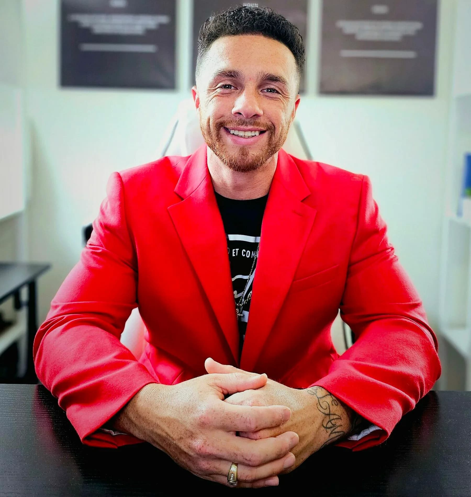 Rudy Perez Jr. seated at a desk in a red jacket
